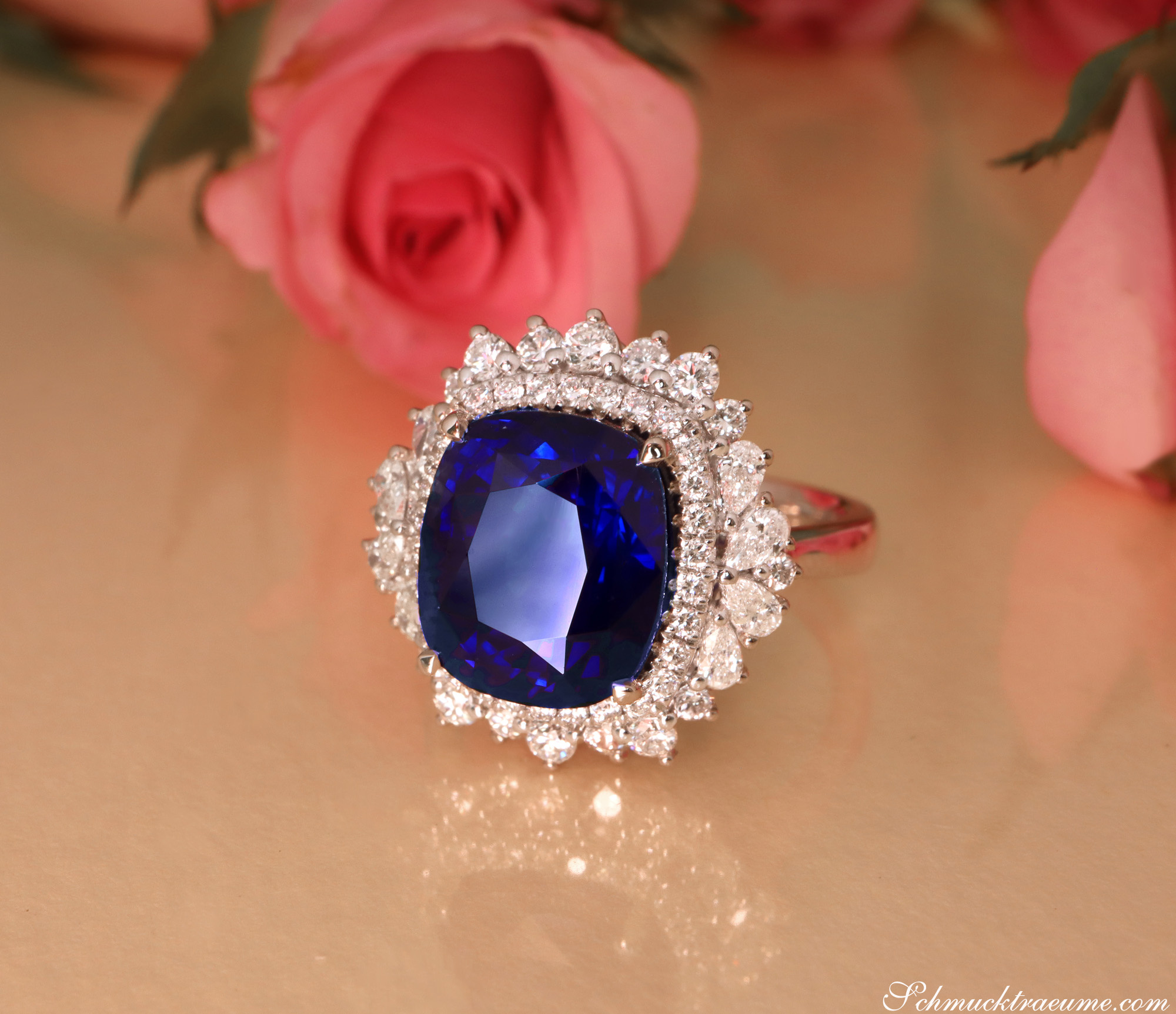 Ceylon Saphir-Ring mit Diamanten in Weißgold, Detailaufnahme, Rosen im Hintergrund.