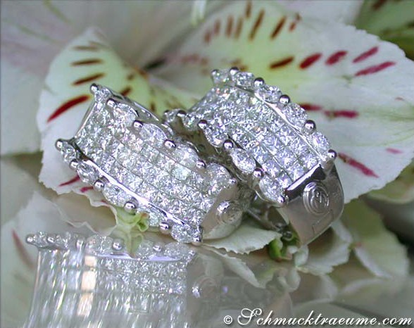 Weißgold-Ohrringe mit Marquise- und Princess-Diamanten, detailreich gestaltet, auf Blütenblättern abgebildet.