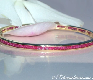 Goldener Rubin-Armreif mit funkelnden Steinen, detailreich, elegant, auf weißem Hintergrund.