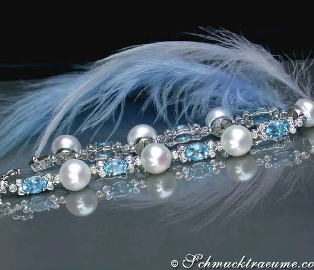 Süßwasserperlen-Armband mit Blautopasen und Brillanten, detailreich, Feder im Hintergrund. Süßwasserperlen-Armband mit Blautopasen und Brillanten, detailreich, Feder im Hintergrund.