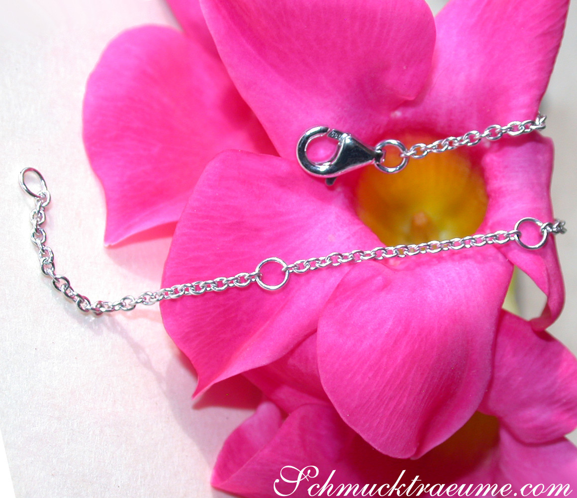 Silbernes Kettchen mit Karabinerverschluss auf rosa Blüte