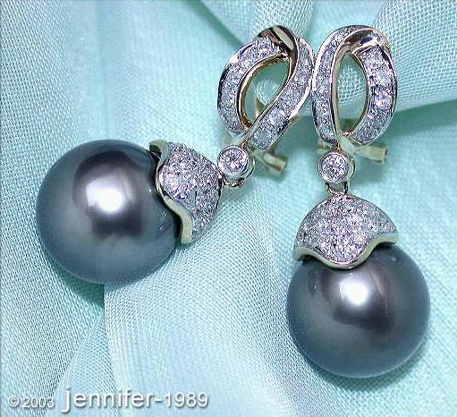 Tahitiperlen-Ohrgehänge in Gelbgold mit Diamanten, Detailaufnahme auf blauem Hintergrund