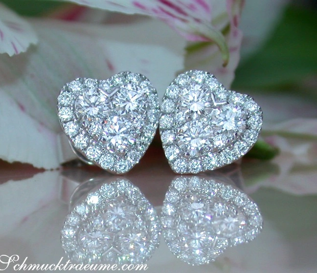 Herzformige Diamantohrstecker in Weißgold 750, prachtvoll auf Blütenblättern platziert. Herzformige Diamantohrstecker in Weißgold 750, prachtvoll auf Blütenblättern platziert.