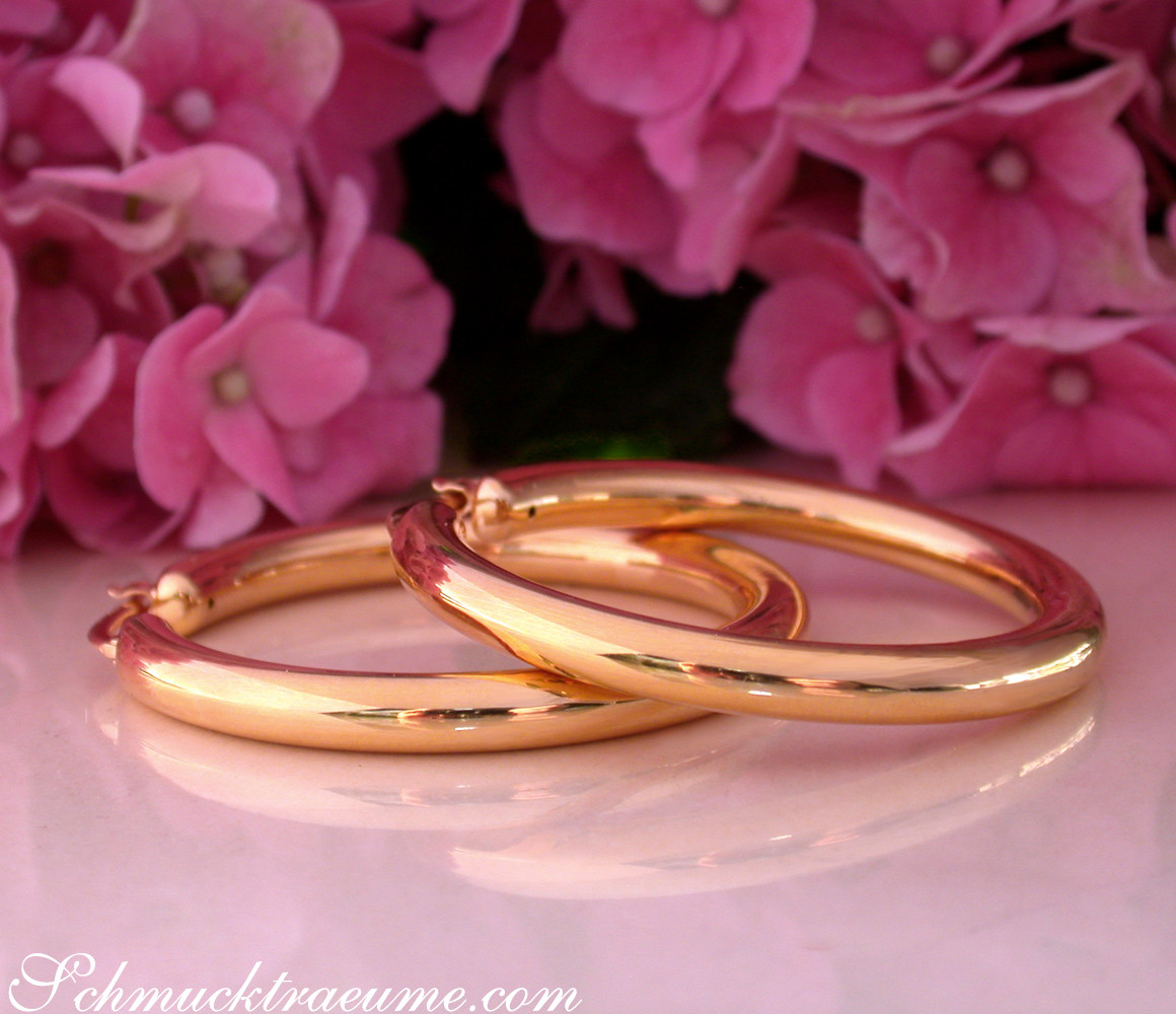 Goldcreolen in Gelbgold 585 mit rosafarbenen Hortensien im Hintergrund