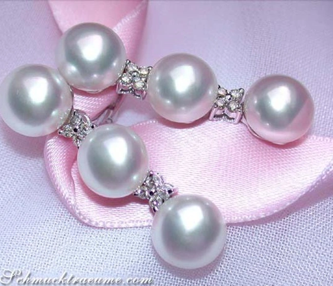 Süßwasserperlen-Ohrhänger mit Diamanten auf rosa Seide getragen Süßwasserperlen-Ohrhänger mit Diamanten auf rosa Seide getragen