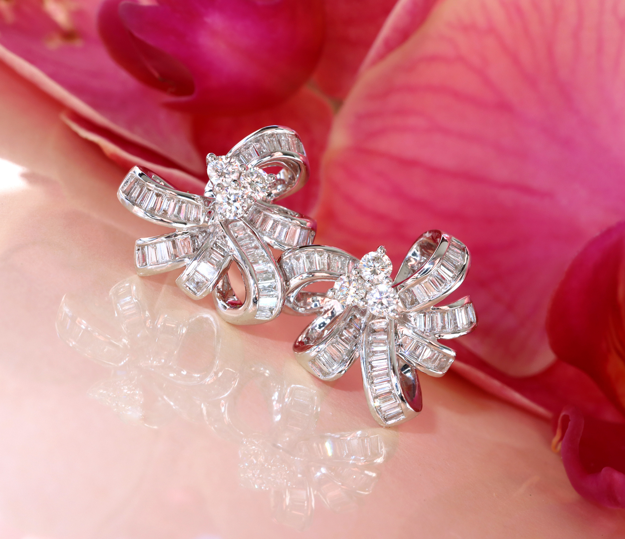 Blumenblätter im Hintergrund, Diamant-Schleifen-Ohrstecker mit Baguette-Diamanten und Weißgold 750