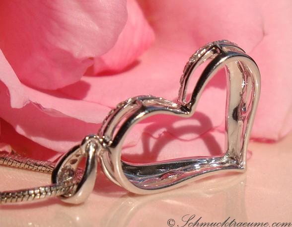 Herz-Anhänger aus Weißgold 585 mit Diamanten, Detailaufnahme, zarte Struktur, rosafarbener Hintergrund