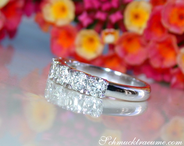 Weiße Diamant-Ring in Weißgold 750, drei Brillanten, Blumen im Hintergrund