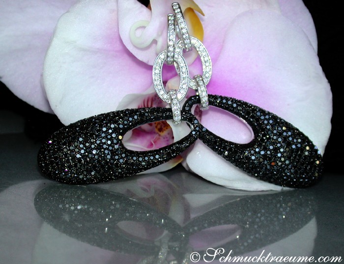 Schwarze Diamant-Ohrgehänge auf Orchideenblüte, Detailaufnahme