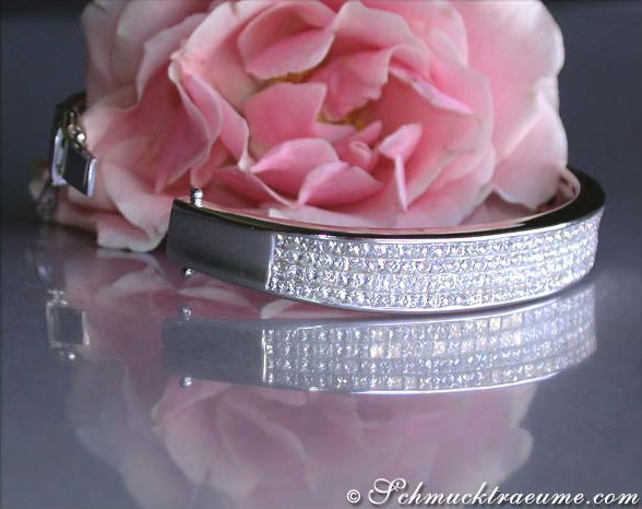 Schimmernder Diamantenarmreif im Invisible Setting mit Rosenblüte im Hintergrund