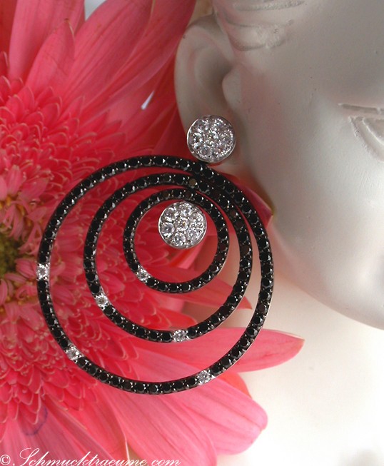 Spiralige Ohrringe aus Weißgold mit schwarzen und weißen Diamanten, detailreich, elegant.