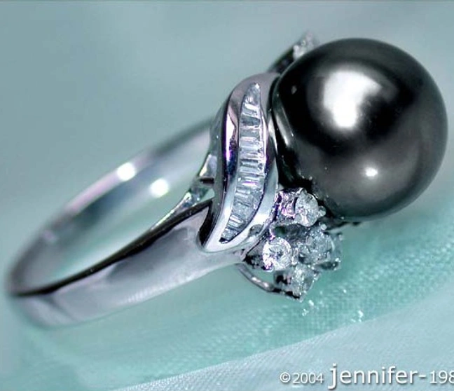 Femininer Tahitiperle-Ring in Weißgold 750, detailreich mit Diamanten, elegant auf weißem Stoff. Femininer Tahitiperle-Ring in Weißgold 750, detailreich mit Diamanten, elegant auf weißem Stoff.