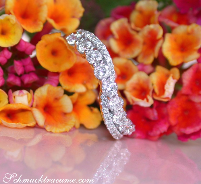 Detailansicht des Überkreuzten Band Rings mit Brillanten auf Blütenhintergrund