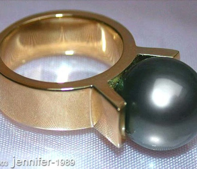 Gelbgoldring mit großen schwarzer Perle, Detailaufnahme, hochglänzend, schlicht elegant Gelbgoldring mit großen schwarzer Perle, Detailaufnahme, hochglänzend, schlicht elegant