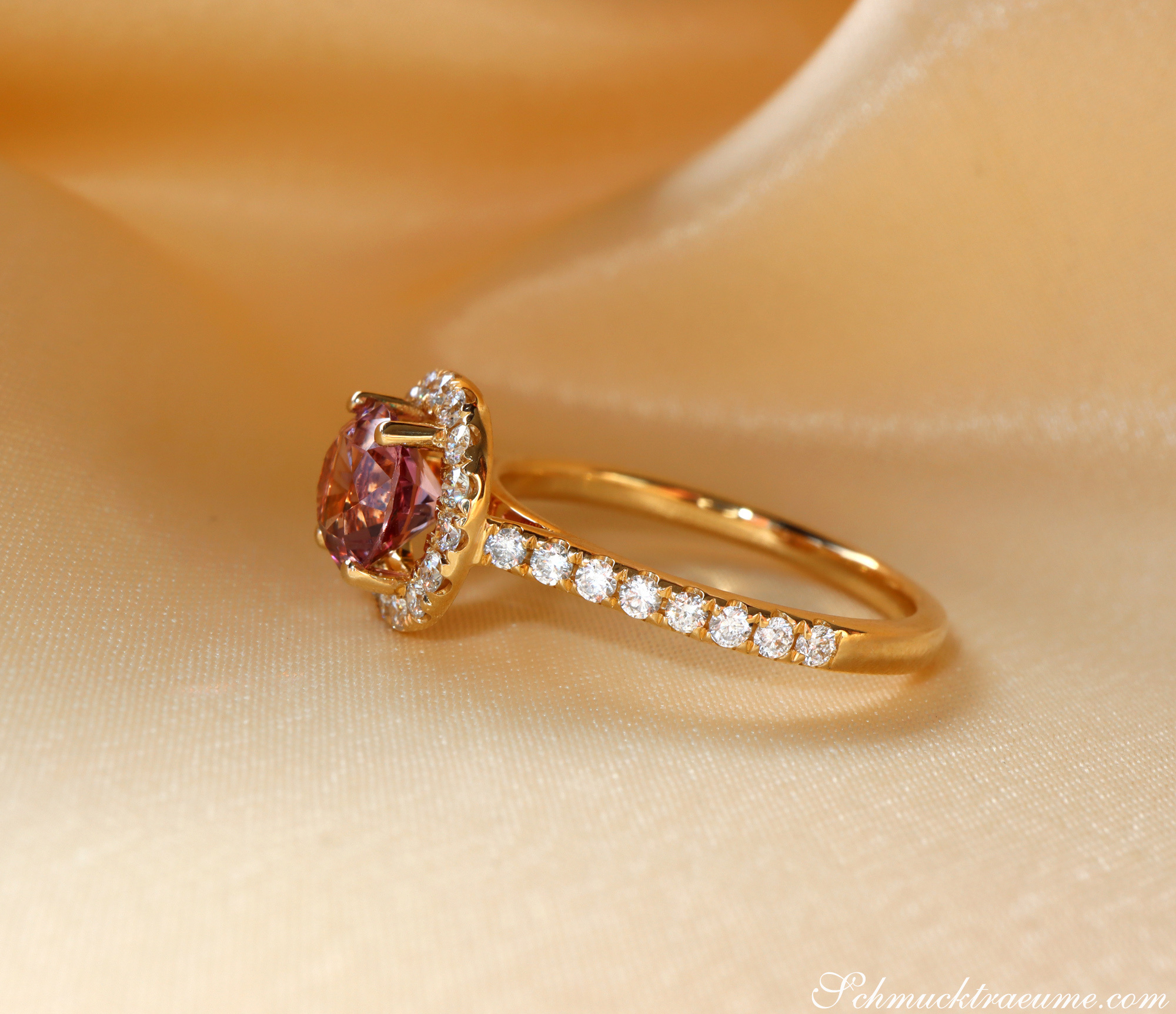 Goldener Malaya Granat-Ring mit Brillanten, Detailaufnahme auf Seide liegend