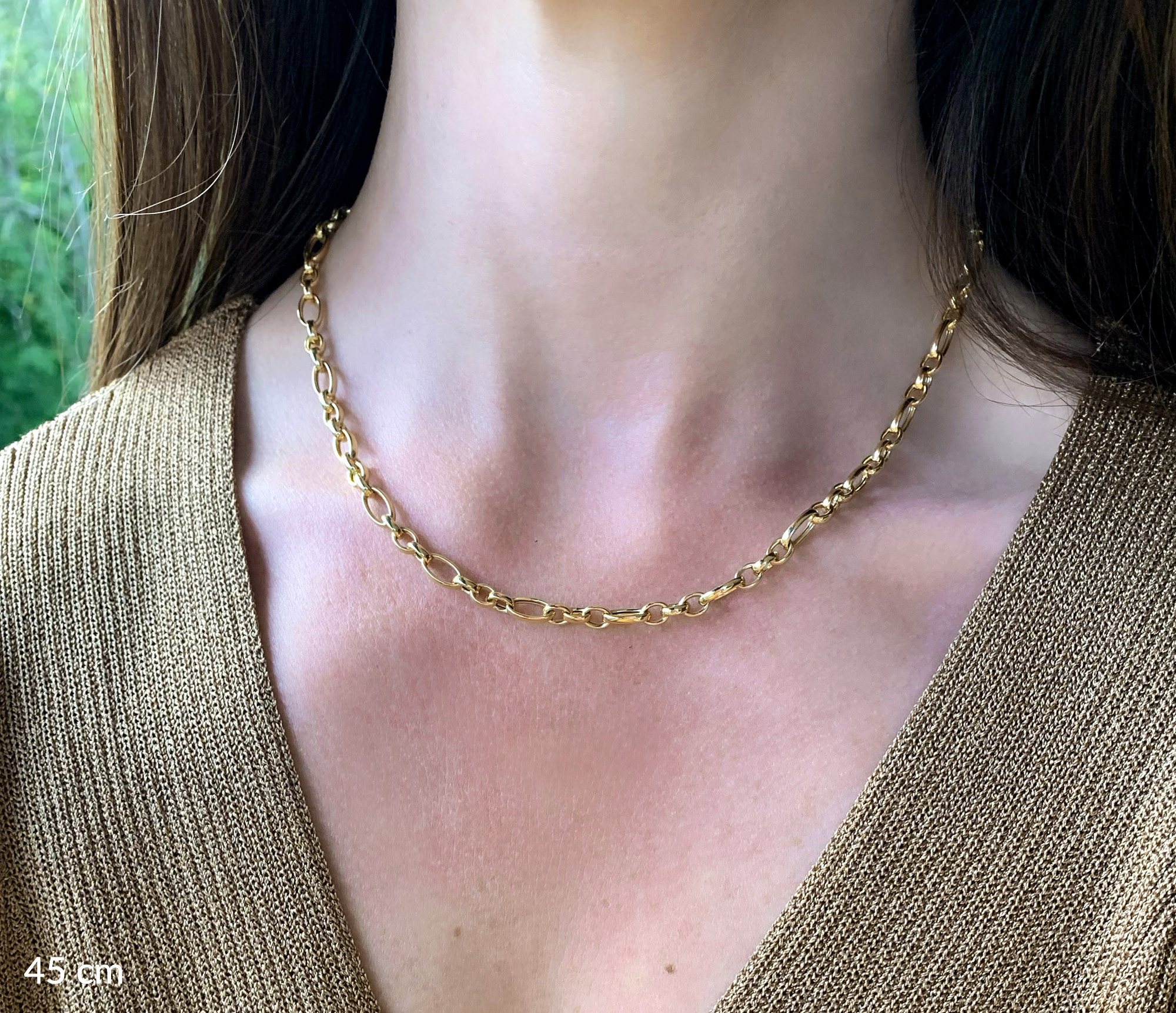 Goldkette mit ovalen und runden Gliedern um den Hals getragen