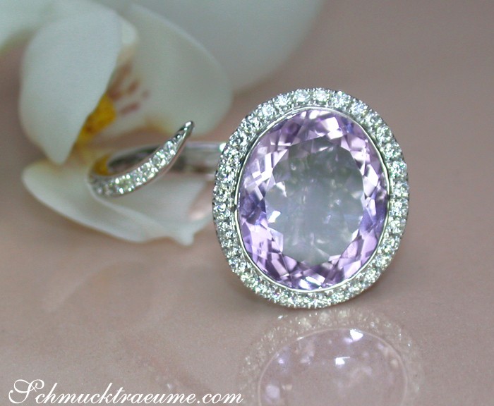 Weißgoldring mit Amethyst und Brillanten, Detailaufnahme, Orchideenblüte im Hintergrund