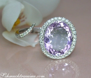 Weißgoldring mit Amethyst und Brillanten, Detailaufnahme, Orchideenblüte im Hintergrund