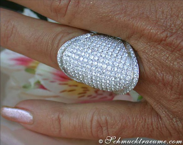 Detail des prunkvollen Brillantringes in Weißgold, makellosem Schliff, auf zartem Finger getragen