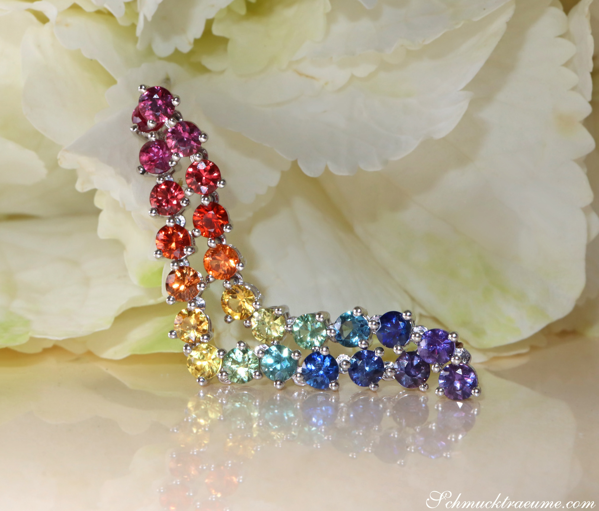 Weißgold-Ohrhänger mit Regenbogen-Saphiren, detailreich, auf Blüte liegend