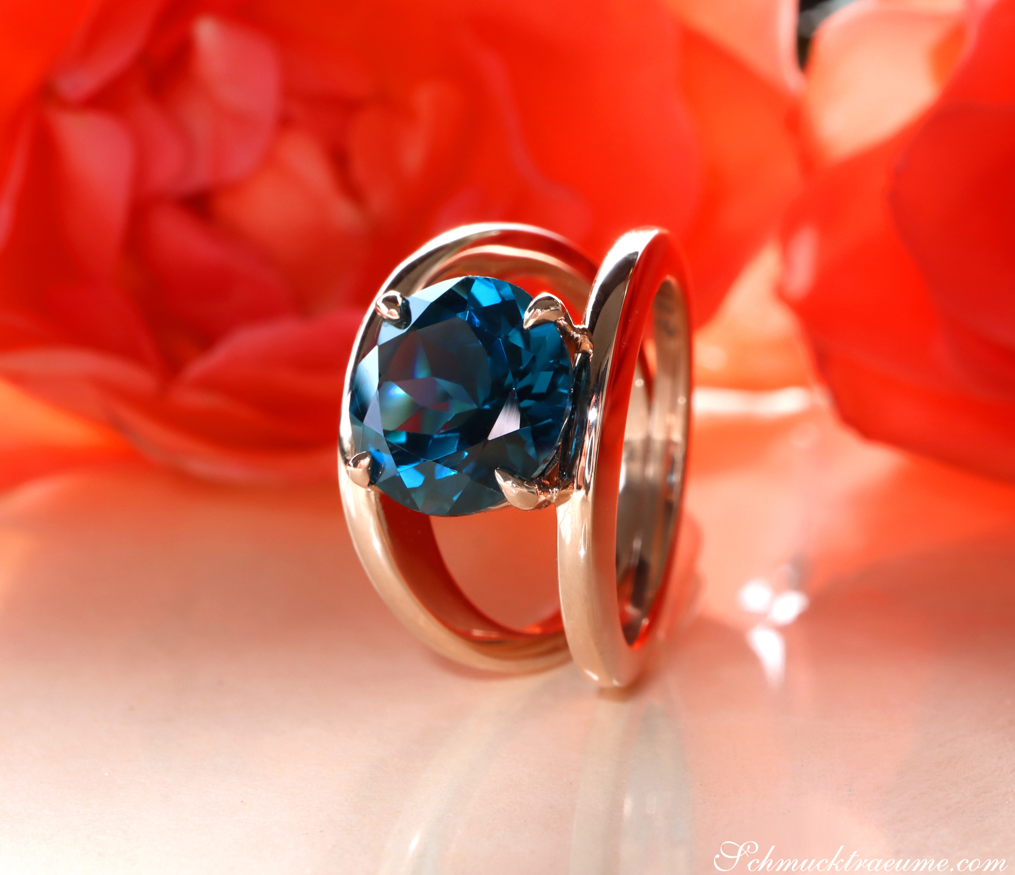 Raffinierter Blautopas-Ring aus Roségold 585, Detailansicht auf rosafarbenem Hintergrund