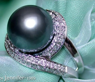 Weißgoldring mit schwarzer Tahitiperle und Diamanten auf grünem Stoff