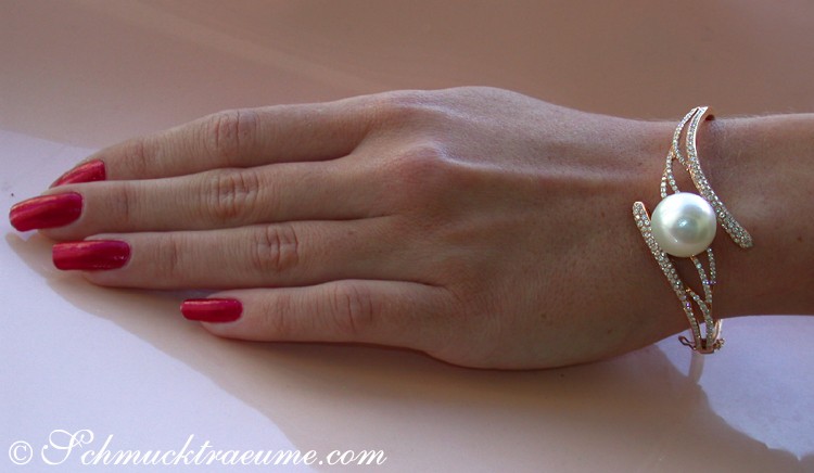 Goldener Armreif mit Südseeperle und Diamanten, getragen auf der Hand
