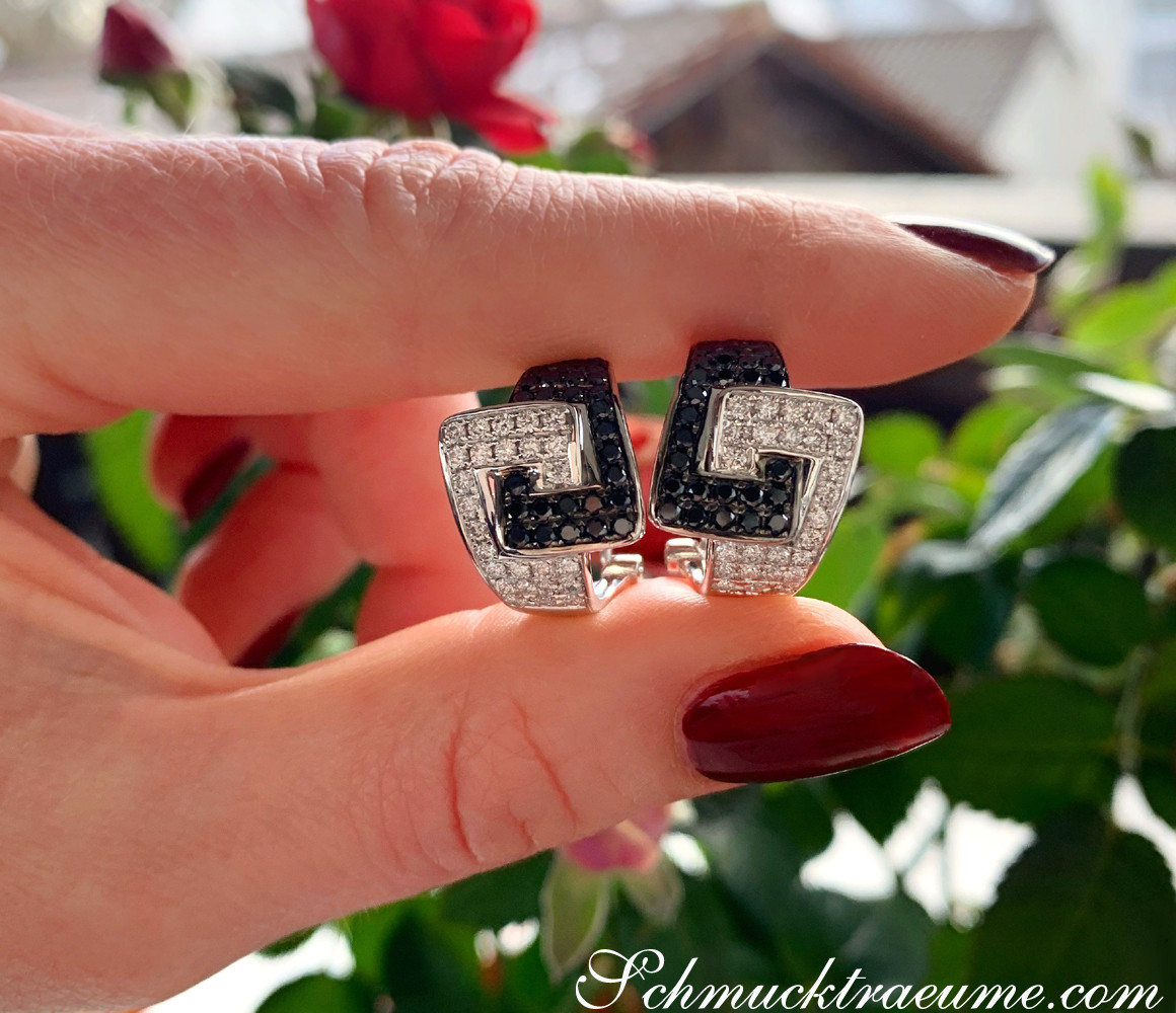 Sportliche Diamant-Ohrstecker in Weißgold, getragen auf Hand mit roten Nagellack