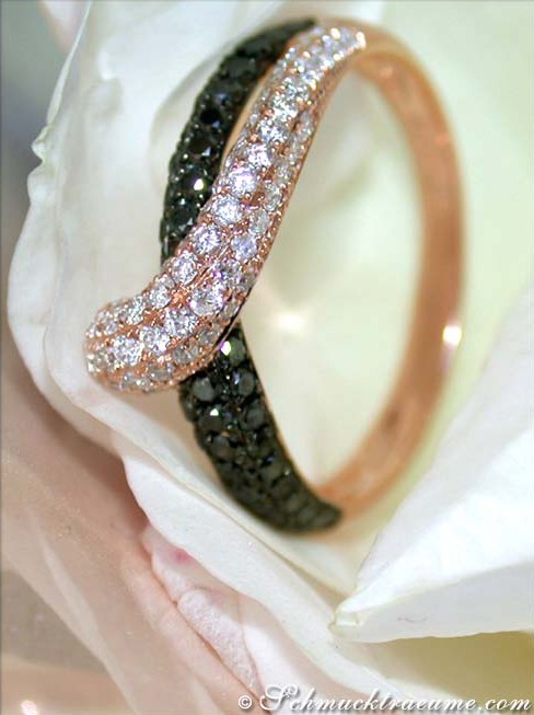 Detailansicht von schwarzen und weißen Diamantringen in Roségold auf Blüte.