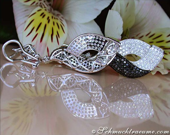 Schwarz-weiße Diamant-Ohrgehänge mit Handarbeit, Detailaufnahme, elegant getragen.