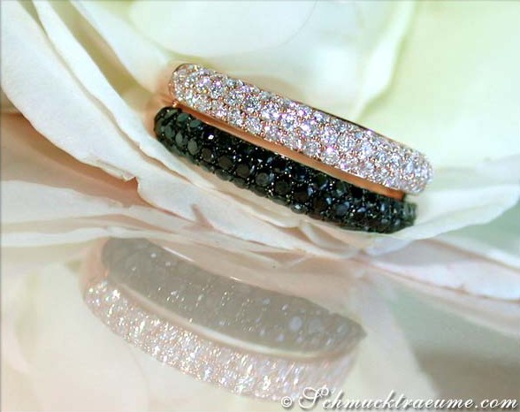 Schwarz-weiß-Diamantring in Roségold auf Blume liegend