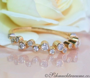 Klassischer Diamantenring in Gelbgold mit feinen Brillanten auf Rosenblatt-Hintergrund