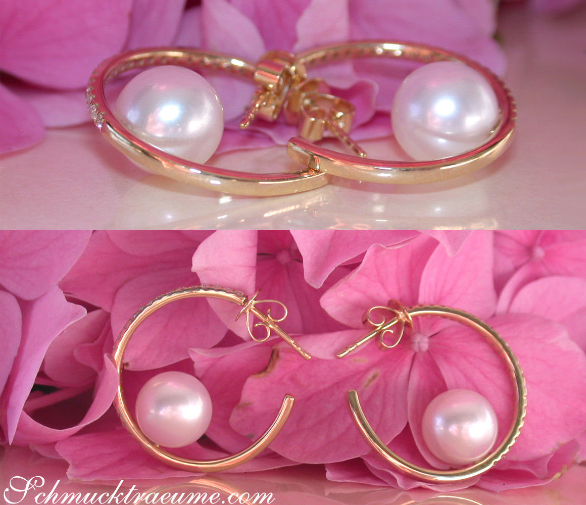 Goldene Creolen mit Perlen auf rosa Blütenblättern