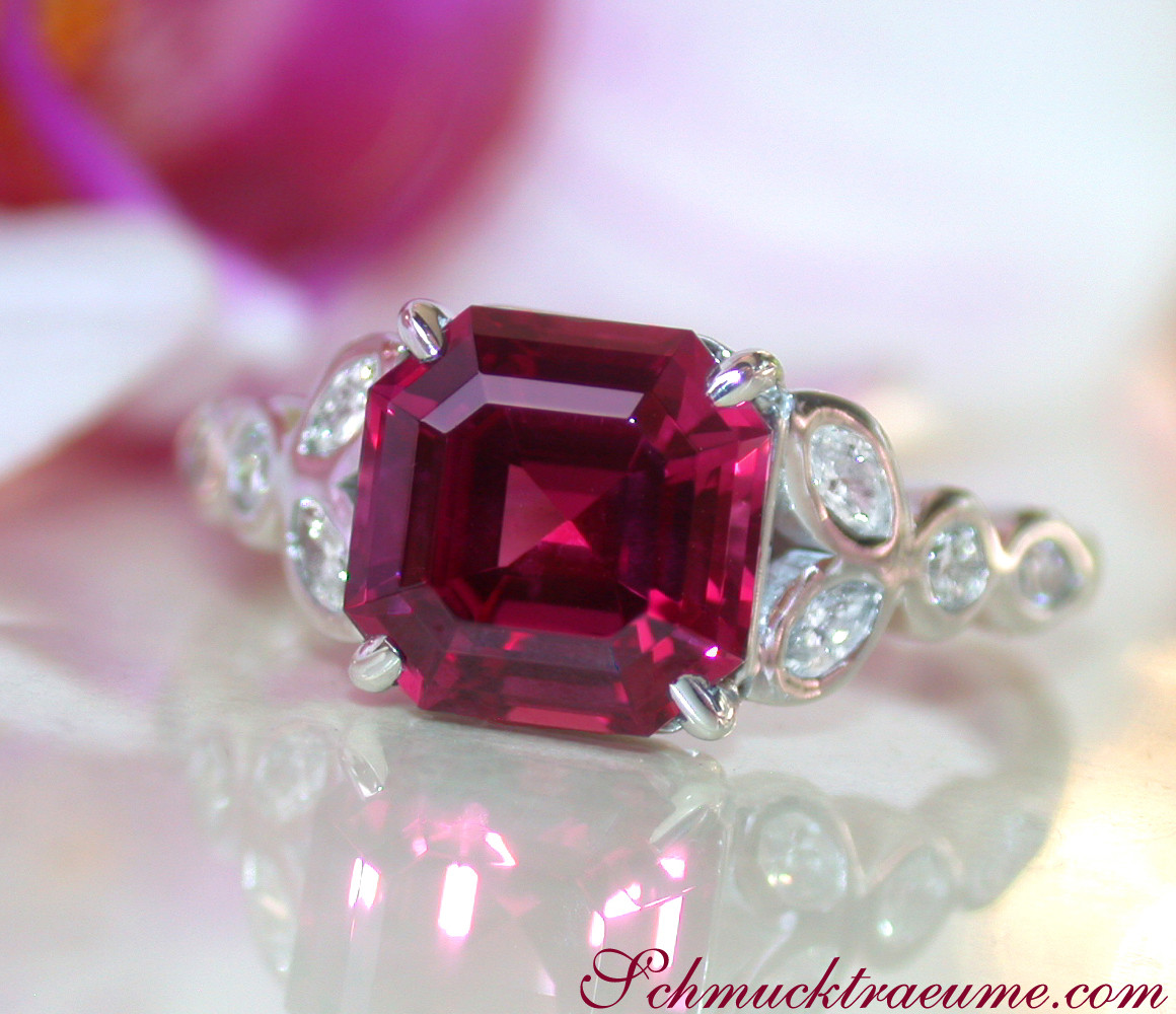 Weißgoldring mit intensiv rotem Rhodolith und Diamanten, detailreich, elegant.
