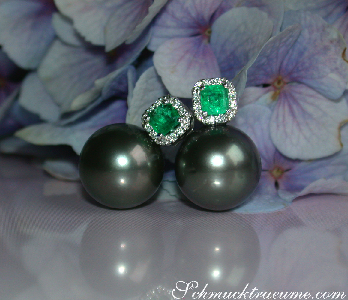 Tahitiperlenohrringe mit Smaragden und Diamanten vor Blütenblättern