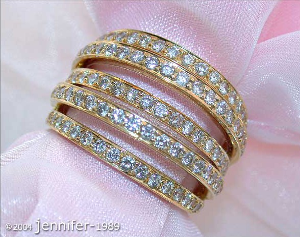 Gelbgold 750 Mehrreihiger Brillanten-Ring, moderner Chic, Detailaufnahme auf rosa Stoff, raffinierter Charme.
