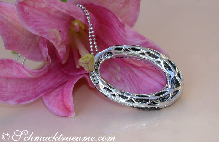 Schwarz-weiß-diamantener Anhänger mit filigraner Verzierung, getragen vor Blume