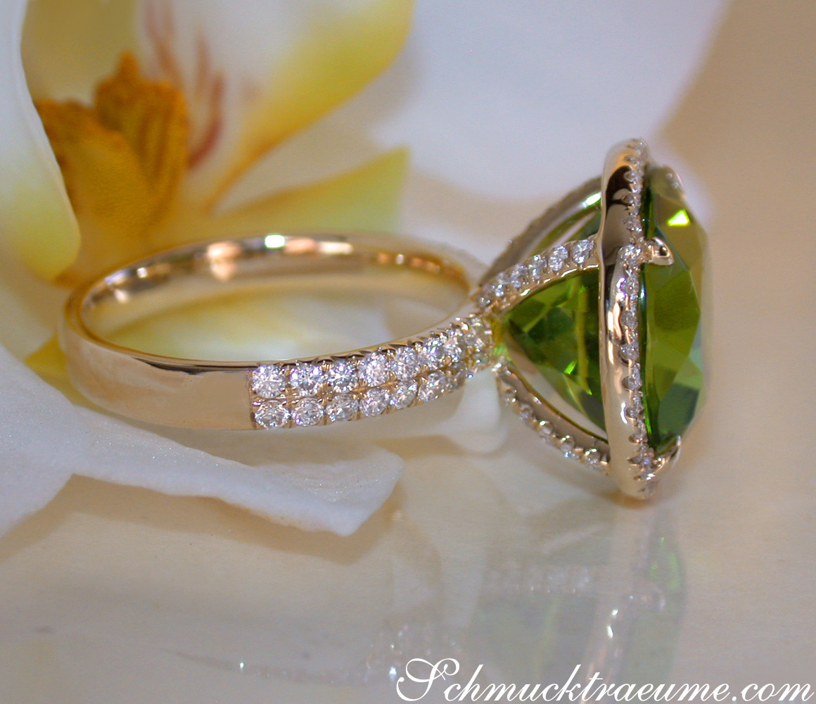 Peridot-Ring mit Brillanten, Gelbgold 750, Detailaufnahme, Blume im Hintergrund