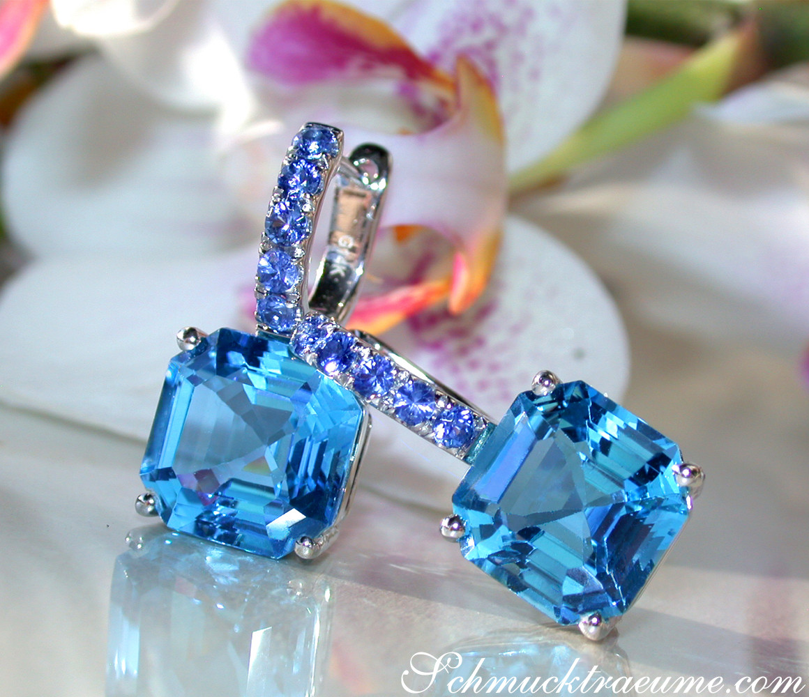 Blautopas-Ohrhänger mit Saphiren, detailreich, weißgold, Orchidee im Hintergrund.