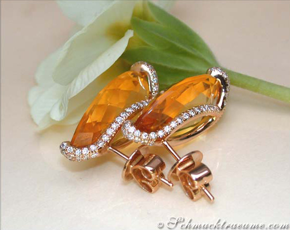 Stattliche Citrin Ohrstecker mit Brillanten auf weißem Hintergrund, Blume im Hintergrund