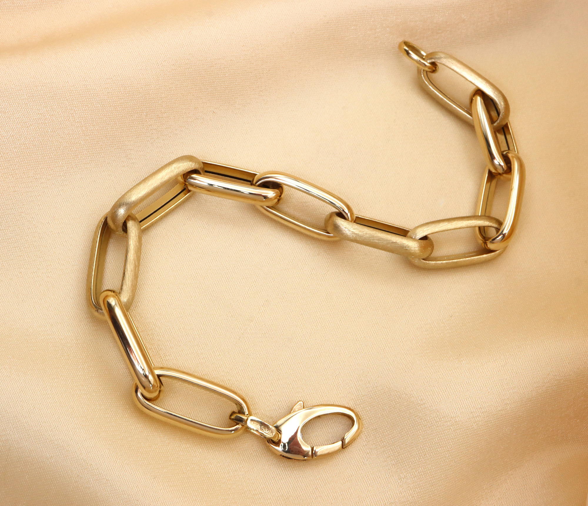 Goldenes Paperclip-Armband aus Gelbgold 585/000, Detailaufnahme mit glänzenden und satinierten Verzierungen auf