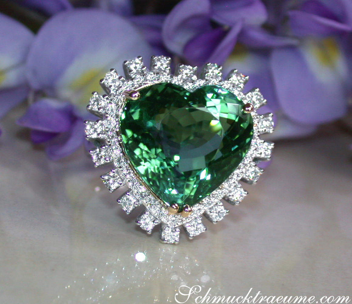 Herzform Turmalin-Ring mit Brillanten in Weißgold, Detailaufnahme, blühende Lilien im Hintergrund.
