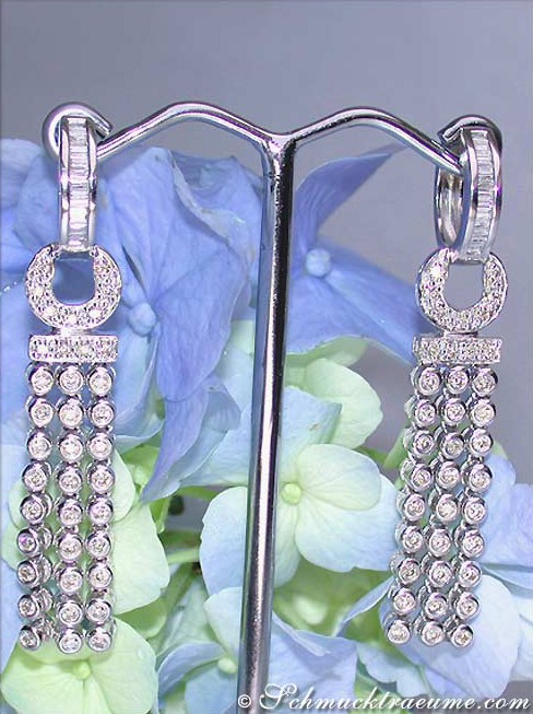 Weißgold-Brillanten-Ohrgehänge auf Blütenhintergrund