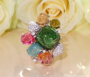 Weißgold-Ring mit Multicolor Turmalin und Diamanten, detailreich, auf Rosenblüte liegend.