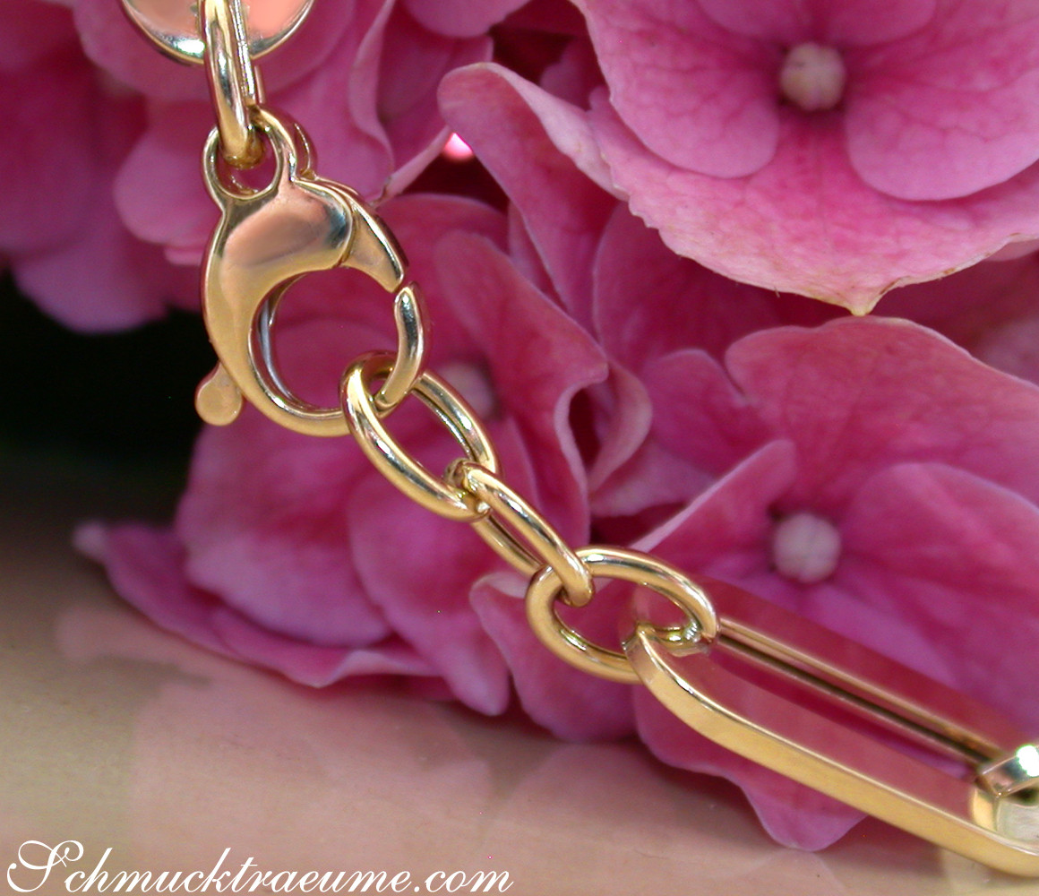 Goldarmband aus Gelbgold 585 mit Paperclip-Design und Blumen im Hintergrund
