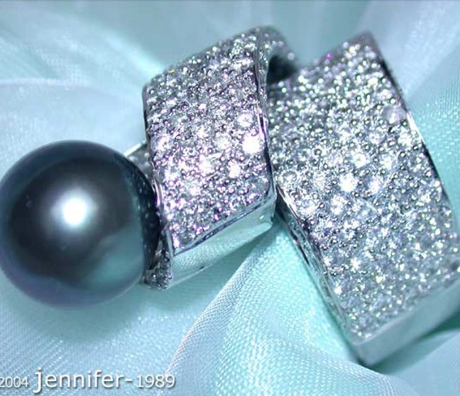 Vollmassiver Tahitiperlen-Ring mit Brillanten in Weißgold, Detailaufnahme auf silberner Seide Vollmassiver Tahitiperlen-Ring mit Brillanten in Weißgold, Detailaufnahme auf silberner Seide