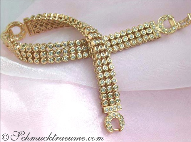 Gelbgold Armband mit Diamanten auf rosa Stoff, Detailaufnahme.