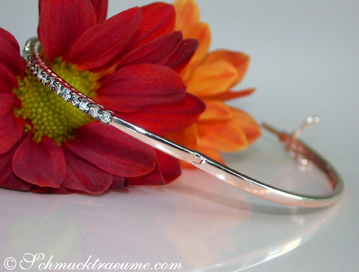 Roségold-Armreif mit naturbraunen Brillanten, Detailaufnahme, Blume im Hintergrund