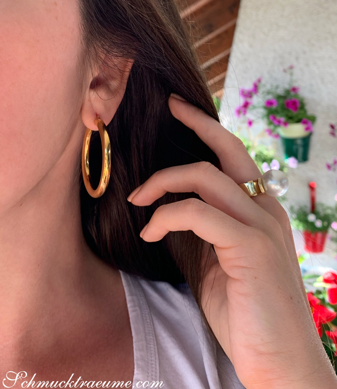 Gold Creolen in Gelbgold 585 (Ø 40 mm) getragen, Detailaufnahme mit Hand im Hintergrund.