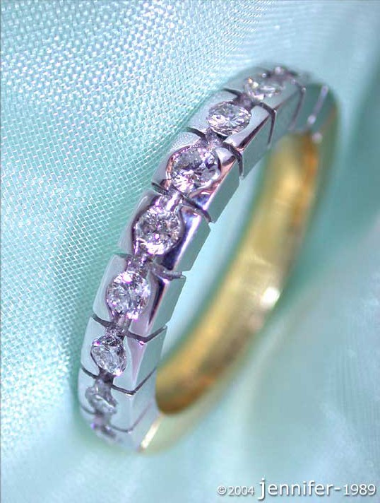 Schwerer Diamanten Memory Ring in Weiß- & Gelbgold 750, Detailaufnahme auf hellblauem Hintergrund